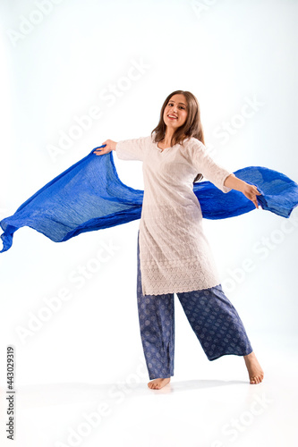 A woman in ethnic wear dancing with her chunni. photo