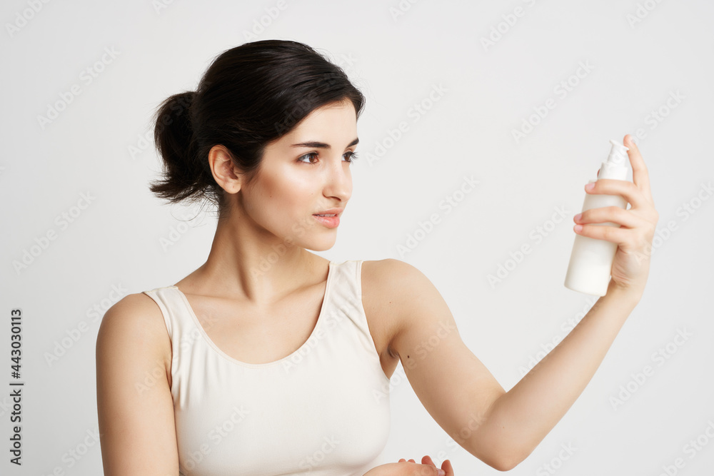 woman in a white t-shirt sat down in her hands moisturizing skin care woman in a white t-shirt sat down in her hands moisturizing skin care