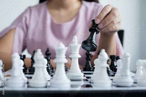 Hand of businesswoman moving, chess in competition shows leadership, followers, and business success strategies