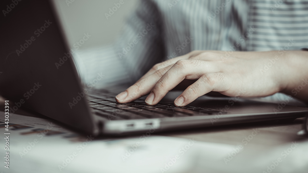 Businesswoman's hand presses on a laptop keyboard, World of technology and internet communication, Using computers to conduct financial transactions because the convenience and speed. Businesswoman's hand presses on a laptop keyboard, World of technology and internet communication, Using computers to conduct financial transactions because the convenience and speed.