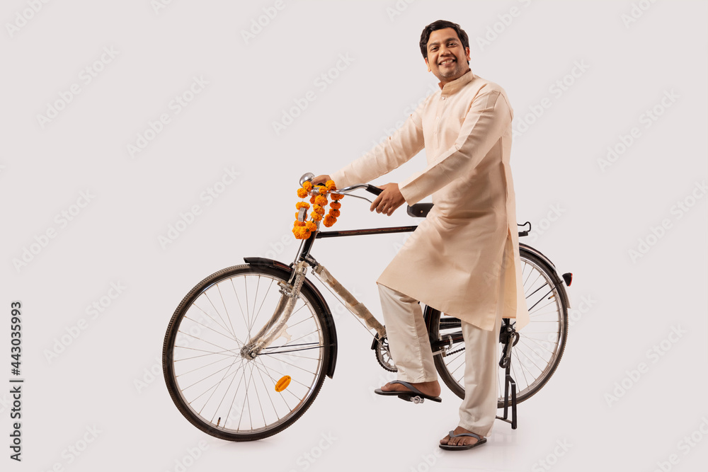A HAPPY RURAL MAN POSING IN FRONT OF CAMERA WITH BICYCLE A HAPPY RURAL MAN POSING IN FRONT OF CAMERA WITH BICYCLE