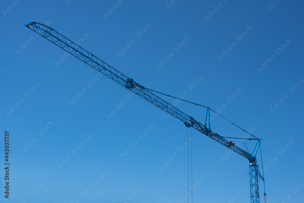 the lattice jib of a blue construction crane the lattice jib of a blue construction crane