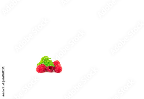 Appetizing red raspberries with a green leaf on a white background