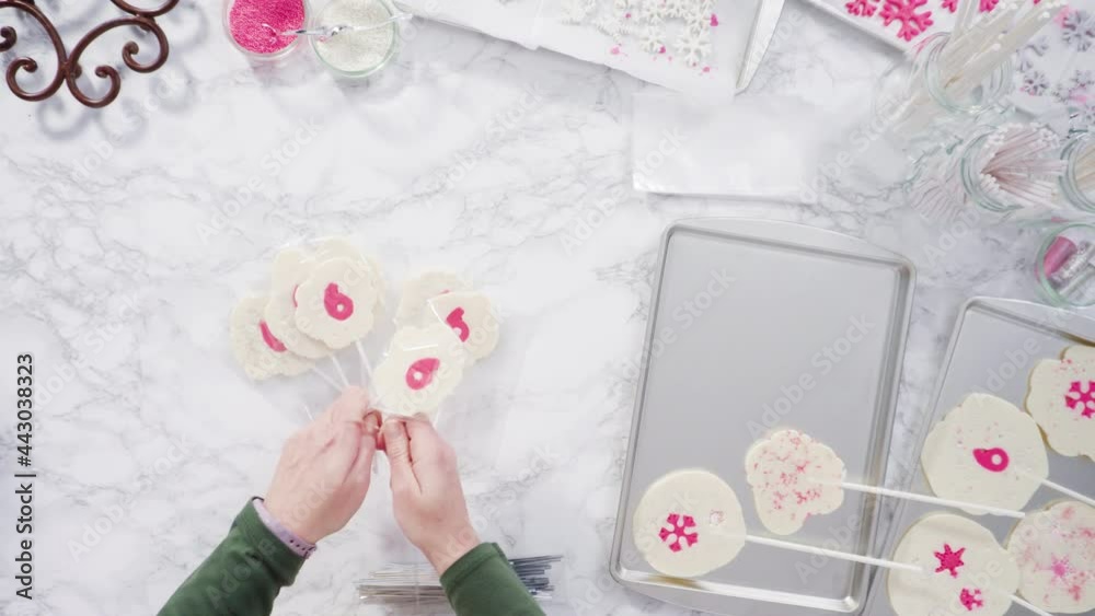 Flat lay. Wrapping large homemade lollipops into clear gift bags. Flat lay. Wrapping large homemade lollipops into clear gift bags.