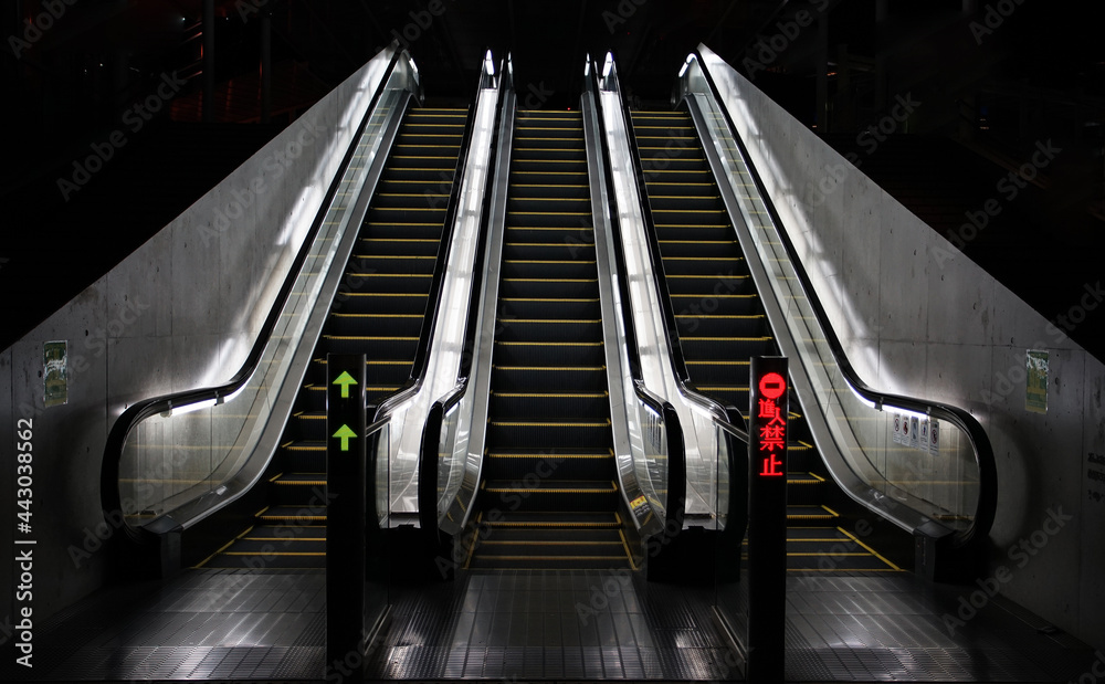 Three escalators at night, illuminated by lights Three escalators at night, illuminated by lights