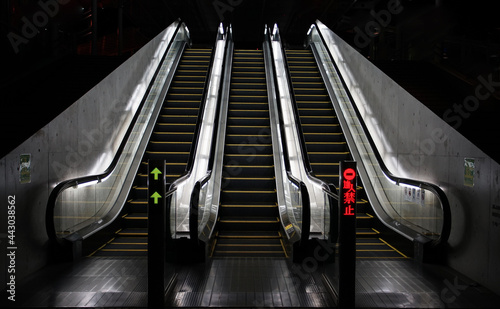 Three escalators at night, illuminated by lights © aozora