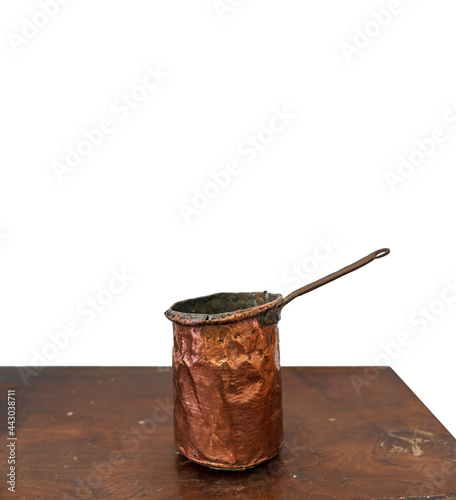 Antique copper saucepan over the table and white background