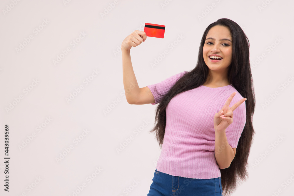 A TEENAGE GIRL HAPPILY POSING IN FRONT OF CAMERA WITH DEBIT CARD A TEENAGE GIRL HAPPILY POSING IN FRONT OF CAMERA WITH DEBIT CARD