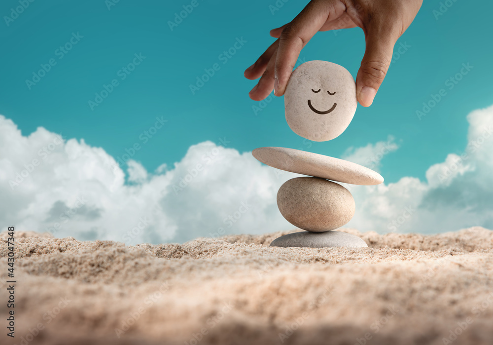Enjoying Life Concept. Harmony and Positive Mind. Hand Setting Natural  Pebble Stone with Smiling Face Cartoon to Balance on Beach Sand. Balancing  Body, Mind, Soul and Spirit. Mental Health Practice Photos