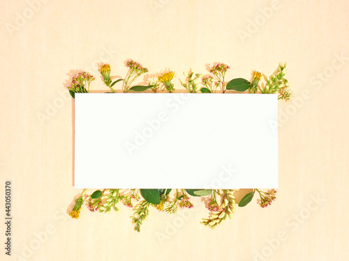 Blank paper with frame of flowers. Flat lay, copy space, top view.