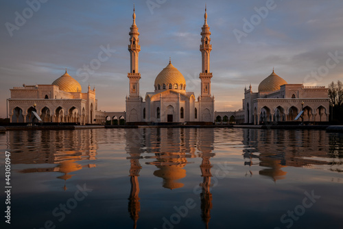 View of the White Mosque of the ancient city Bolgar with a reflection in the water in the evening rays of the setting sun. Bolgar, Republic of Tatarstan, Russia photo