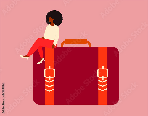 African entrepreneur woman sits on a big handbag with confidence and proud. A black businesswoman looks smart and strong with a business briefcase. Leadership, management, women empowerment concept.