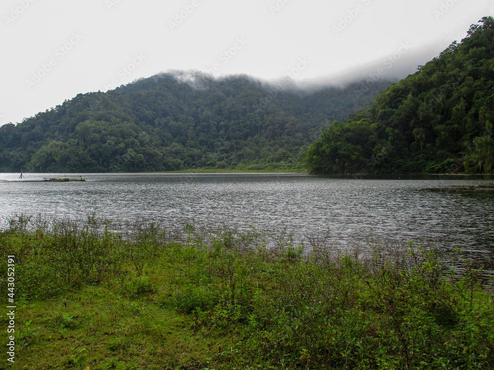 Lake Nunungan with trees and a mountain in the background in Mt. Inayawan Natural Park, Lanao del Norte, Philippines Lake Nunungan with trees and a mountain in the background in Mt. Inayawan Natural Park, Lanao del Norte, Philippines