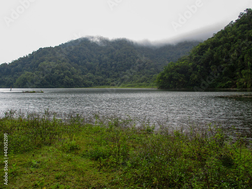 Lake Nunungan with trees and a mountain in the background in Mt. Inayawan Natural Park, Lanao del Norte, Philippines photo