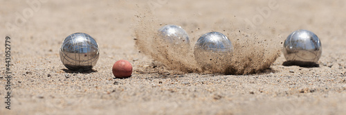 Petanque ball boules bowls on a dust floor, photo in impact. Balls and a small wood jack photo