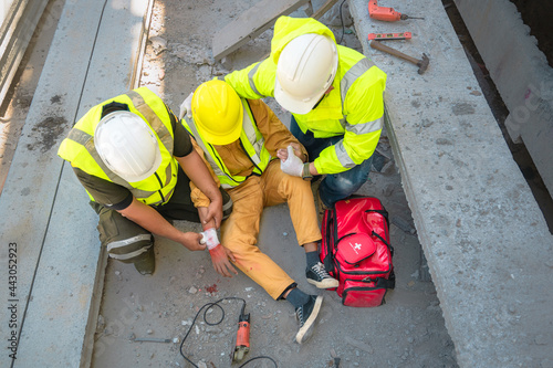 Construction worker has an accident at a construction site. Emergency help engineers provide first aid to construction workers in accidents. Safety team help a construction worker who has an accident.