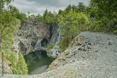 looking down into Hodge Close, an abandoned slate quarry in the Lake District with steep slate walls and a deep pool popular with divers. Skull reflection in the quarry pool. photo