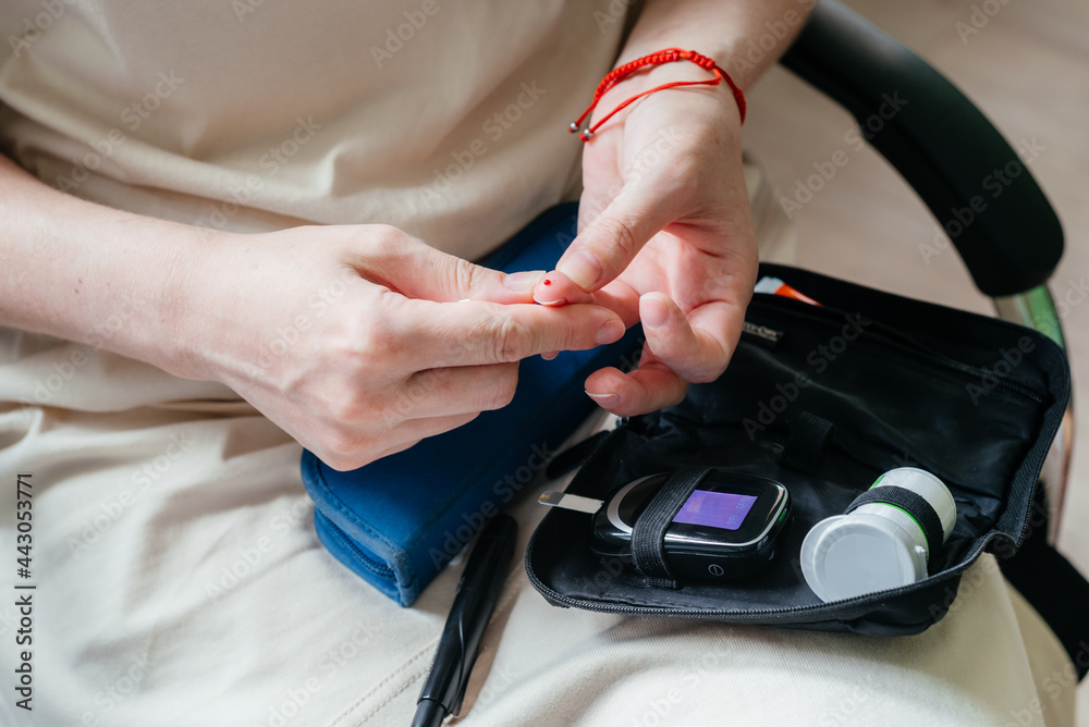 Diabetes woman testing the amount of blood glucose with a portable home glucose meter or blood glucose monitoring device, diabetes world day.