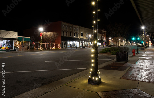 Fototapeta Naklejka Na Ścianę i Meble -  Main street in downtown Raeford North Carolina at night with its Christmas lights and festive decorations reflecting other small towns in America during the holidays