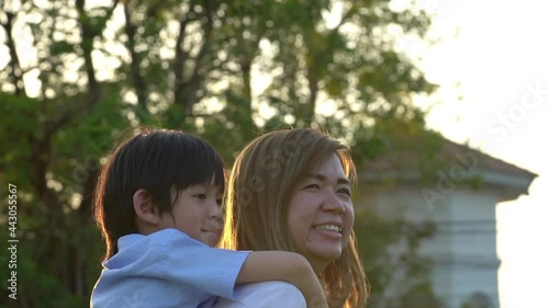 Asian Child On A Piggy Back Ride With His Mother Outdoor