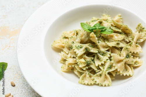 Plate with tasty pesto pasta on table