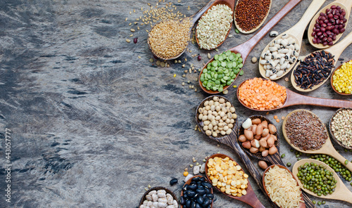 Variety kinds of dry organic cereal and grain seeds in wooden spoon on grunge background, for carbohydrate or clean food ingredient and agricultural product concept