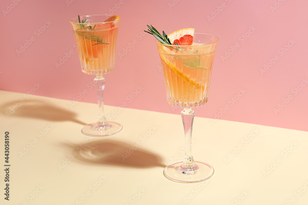 Glasses of tasty grapefruit cocktail on color background