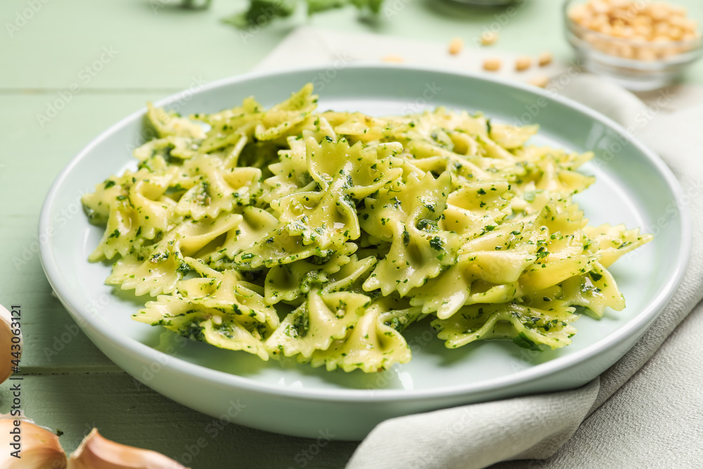 Plate with tasty pesto pasta on table