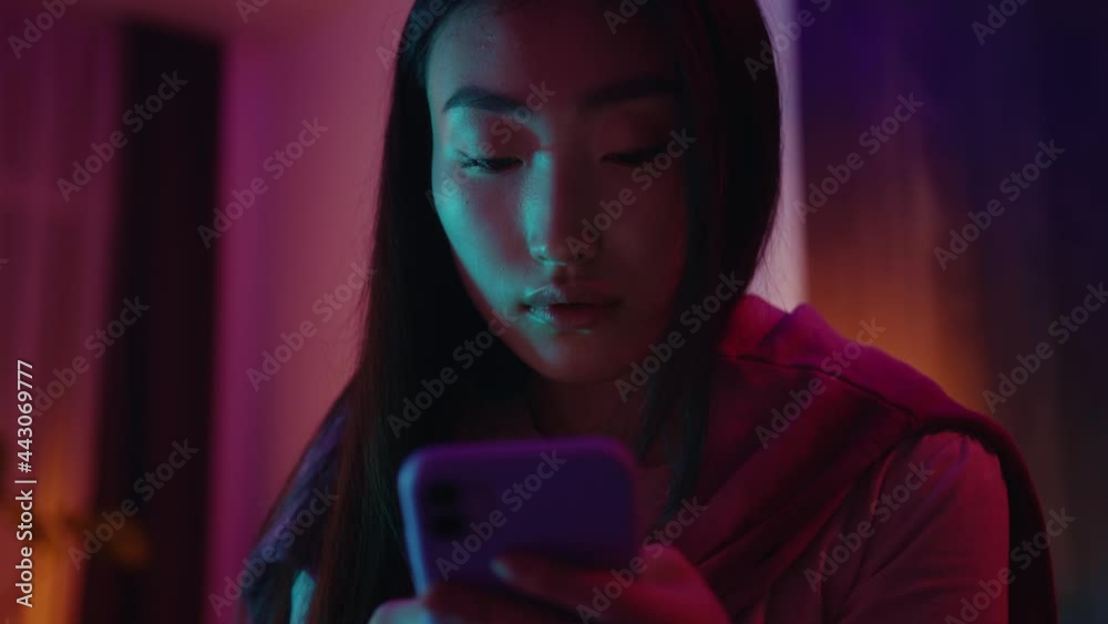 Beautiful young asian japanese woman holding smartphone typing mobile message sms texting to boyfriend communicating while staying home.