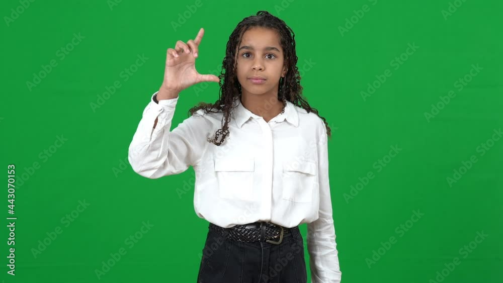 Concentrated teen African American girl imitating screen scrolling at chromakey background. Front view portrait of intelligent focused teenager using futuristic virtual reality on green screen Concentrated teen African American girl imitating screen scrolling at chromakey background. Front view portrait of intelligent focused teenager using futuristic virtual reality on green screen