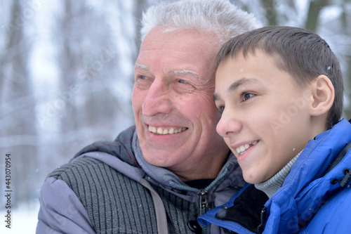 Portrait of smiling senior man and boy standing outdoors in winter © aletia2011