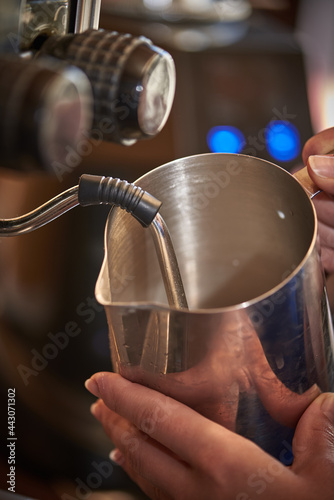 Close up barista using espresso machine milk frother