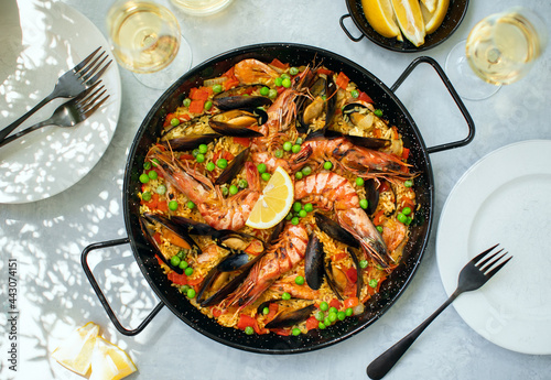 Seafood paella ready to eat served in a paella pan, top-down view photo
