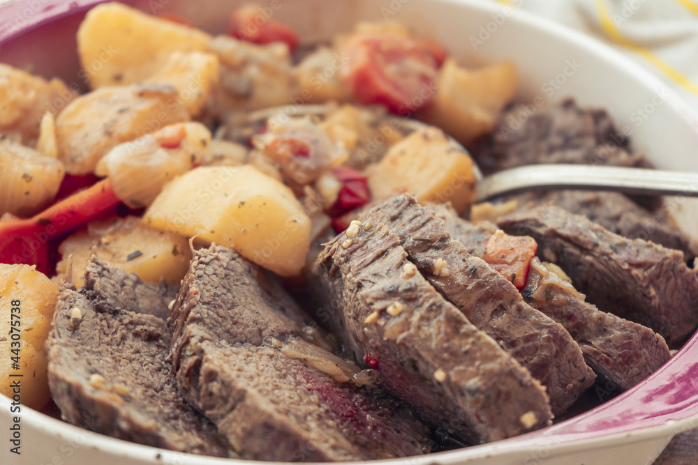 Close-up of a normal view of a platter with homemade meat stew with potatoes and carrots. Homemade food concept, natural food.