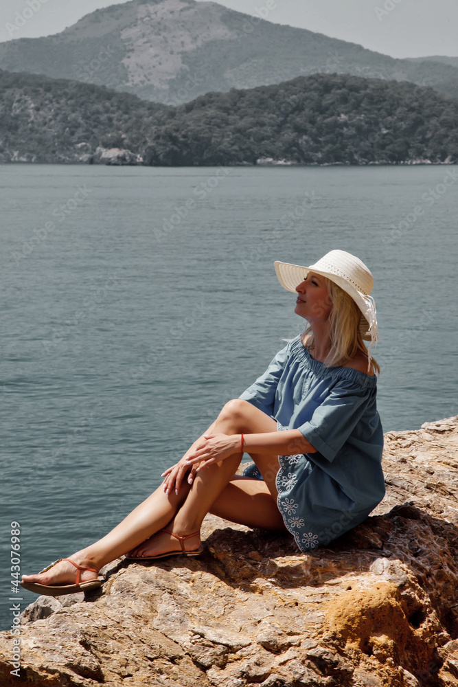 Young woman enjoying holiday on rock with luxury view