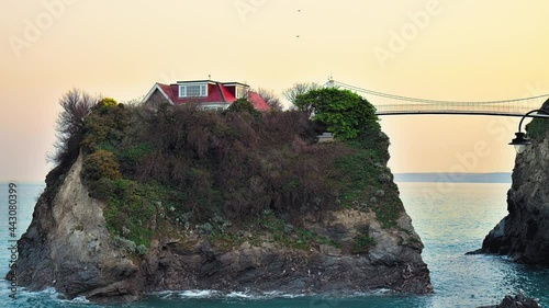 The bridge that links the island house to the mainland at Towan Beach in Newquay. The Island House Bridge near Great Western Beach in Newquay, Cornwall, England in 4K.  photo