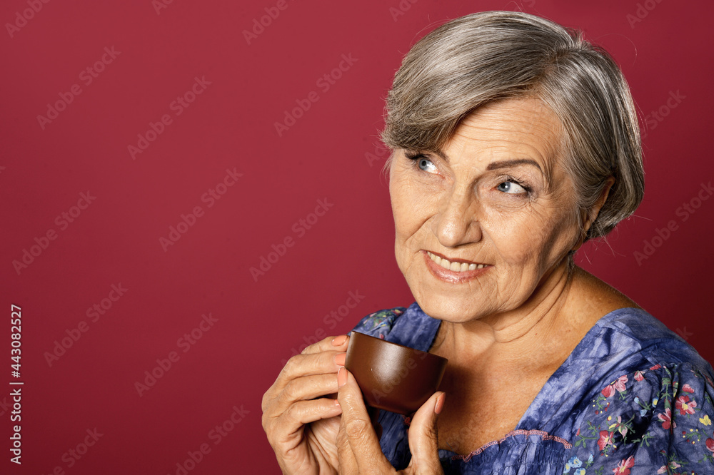 Fototapeta premium Close up portrait of beautiful smiling senior woman drinking tea