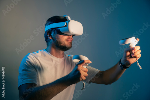 young man wearing Virtual Reality   VR Headset. VR for gaming. Man play game in VR glasses. Hipster with virtual reality headset. 