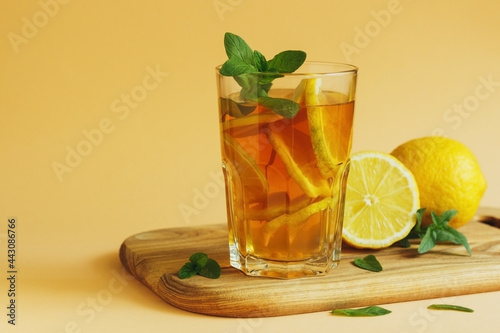 Fresh And Cold Ice Tea With Lemon And Mint on yellow background.