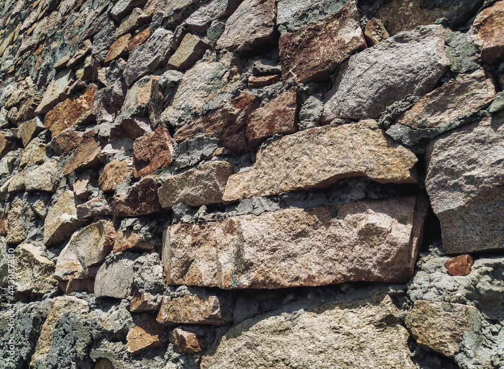 Fototapeta premium The masonry wall is made of large natural granite blocks.