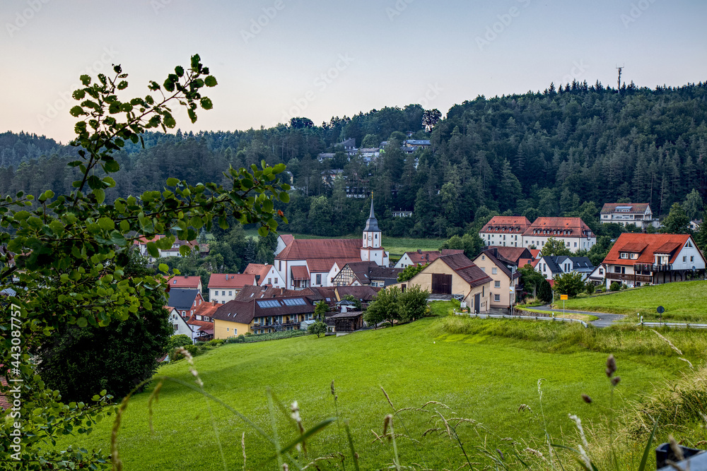 scenic view of a village with a church  in the mountains 
