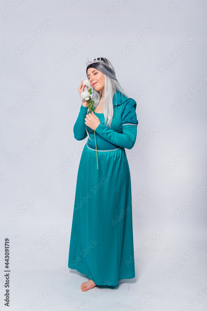 Full length portrait of a princess in a medieval, fantasy, turquoise dress with ash hair and a silver crown, posing with white roses in hands, isolated on a white background.