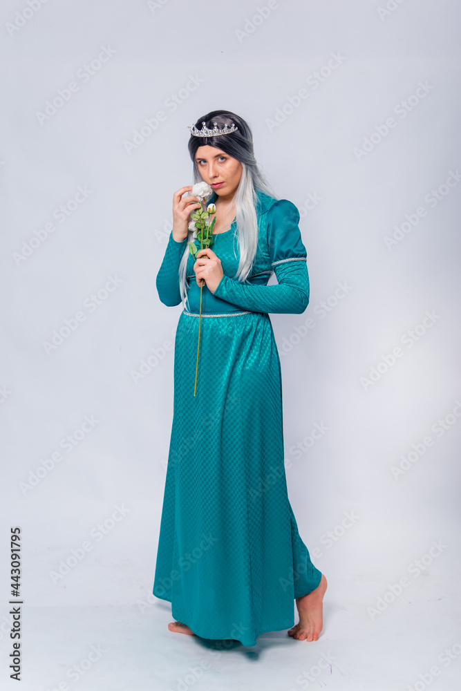 Full length portrait of a princess in a medieval, fantasy, turquoise dress with ash hair and a silver crown, posing with white roses in hands, isolated on a white background.