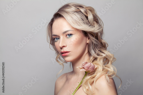 Beauty portrait of spa model woman. Healthy skin and long blonde hair with curly hairstyling. Facial treatment and spa picture.