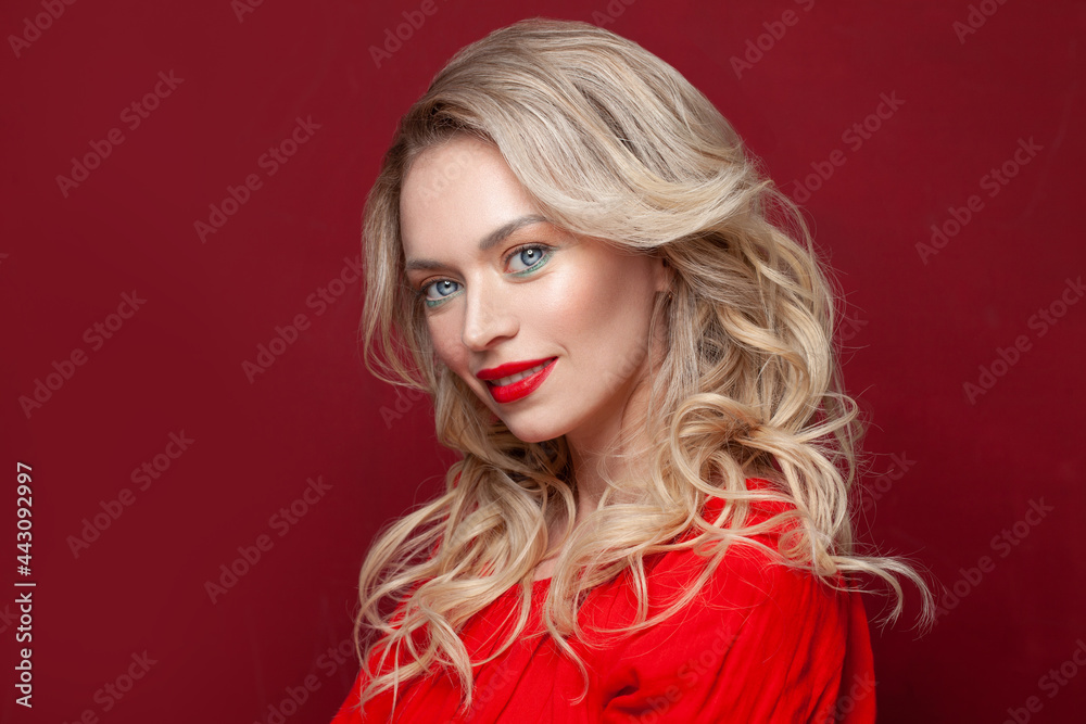 Cute model with perfect smile and beautiful face isolated on red. Nice blonde woman with make up portrait