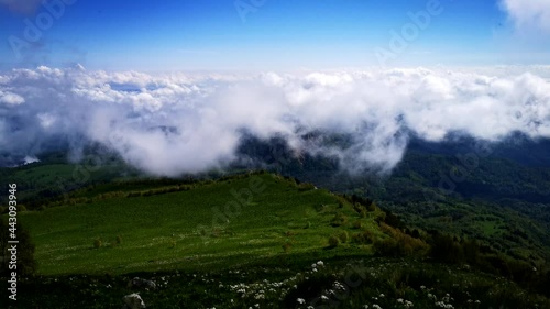 Flower fields, fast flying clouds in mountain landscape. Timelapse video