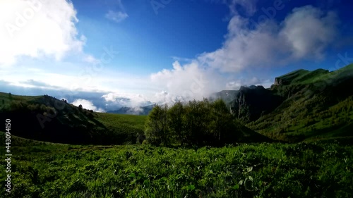 Flower fields, fast flying clouds in mountain landscape. Timelapse video