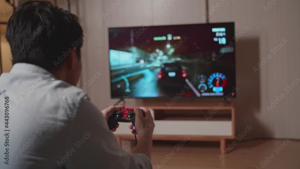 Side View Of Young Man Gamer Playing Car Race Game On Tv At Home
Side View Of Young Man Gamer Playing Car Race Game On Tv At Home