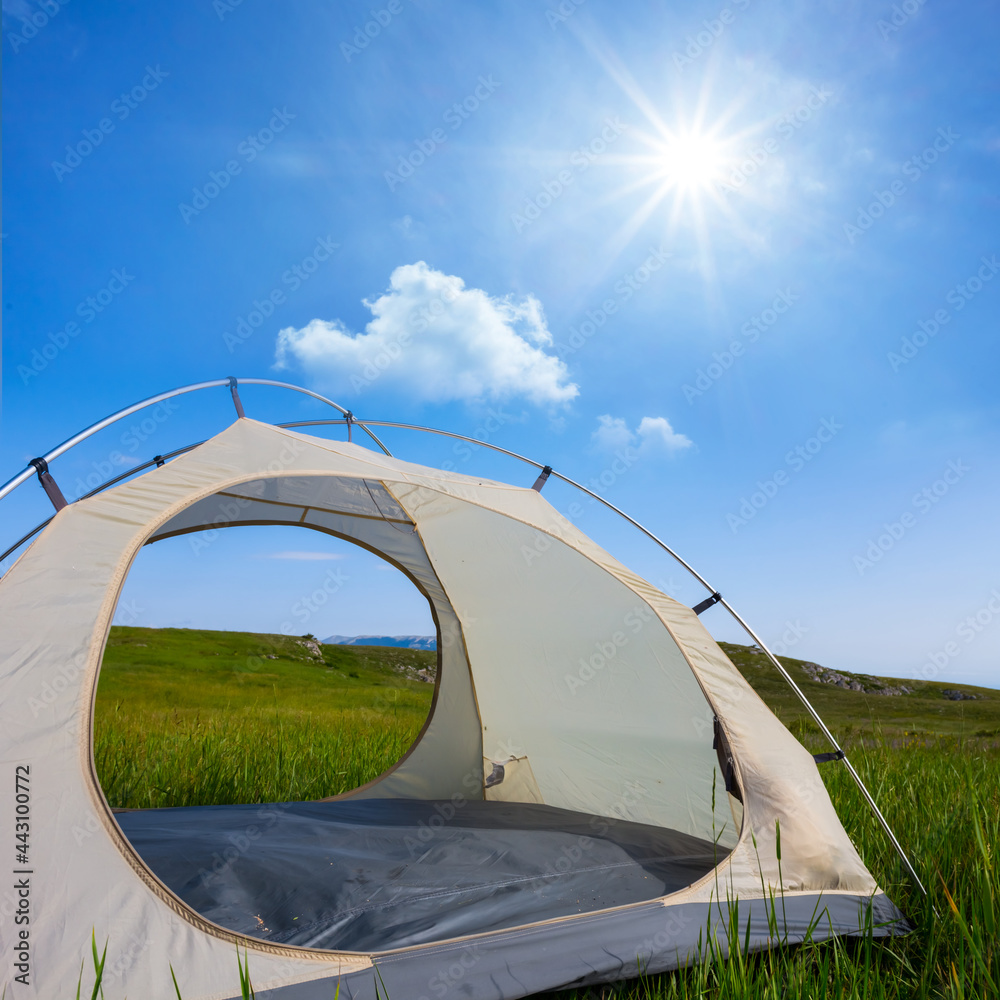 touristic tent stay on mountain plateau in light of sparkle sun, travel background