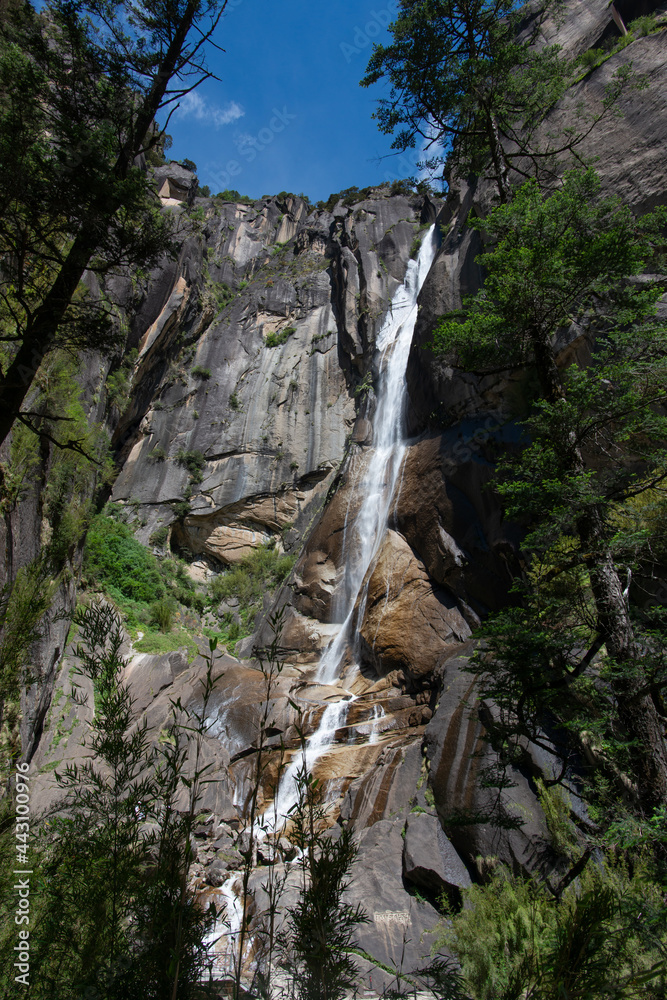 Fototapeta premium Waterfall and Mountains in Kadinggou Scenic Spot, Nyingchi, Tibet, China